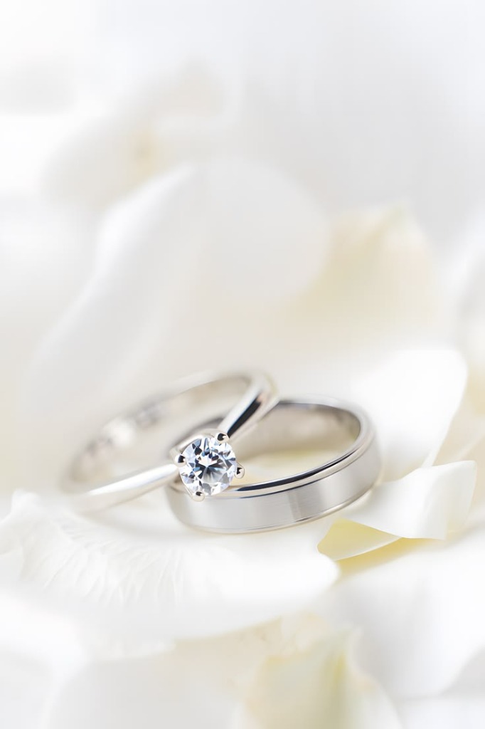 Cincin pernikahan di atas kelopak bunga putih